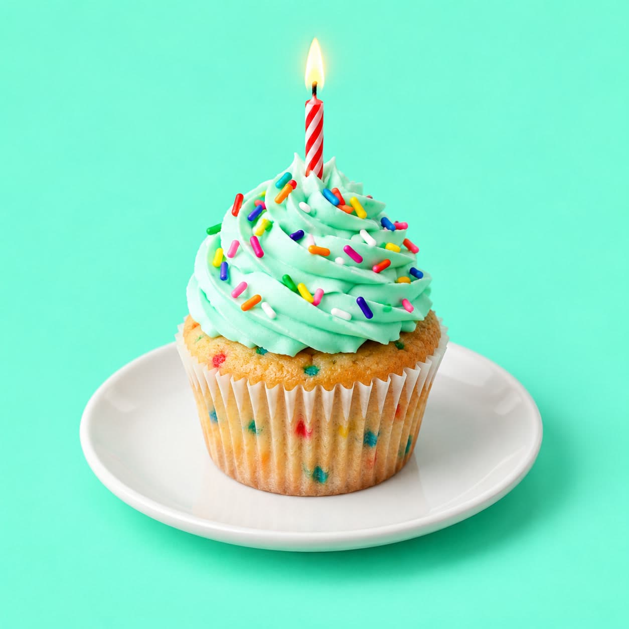 A cupcake with mint frosting and sprinkles